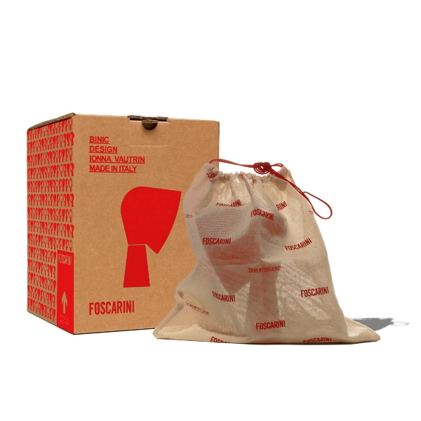 La lampada da tavolo Binic Special Edition colore rosso opaco, viene venduta in una scatola natalizia all’interno di un sacchetto realizzato in tessuto filato allo stato grezzo con logo Foscarini.
